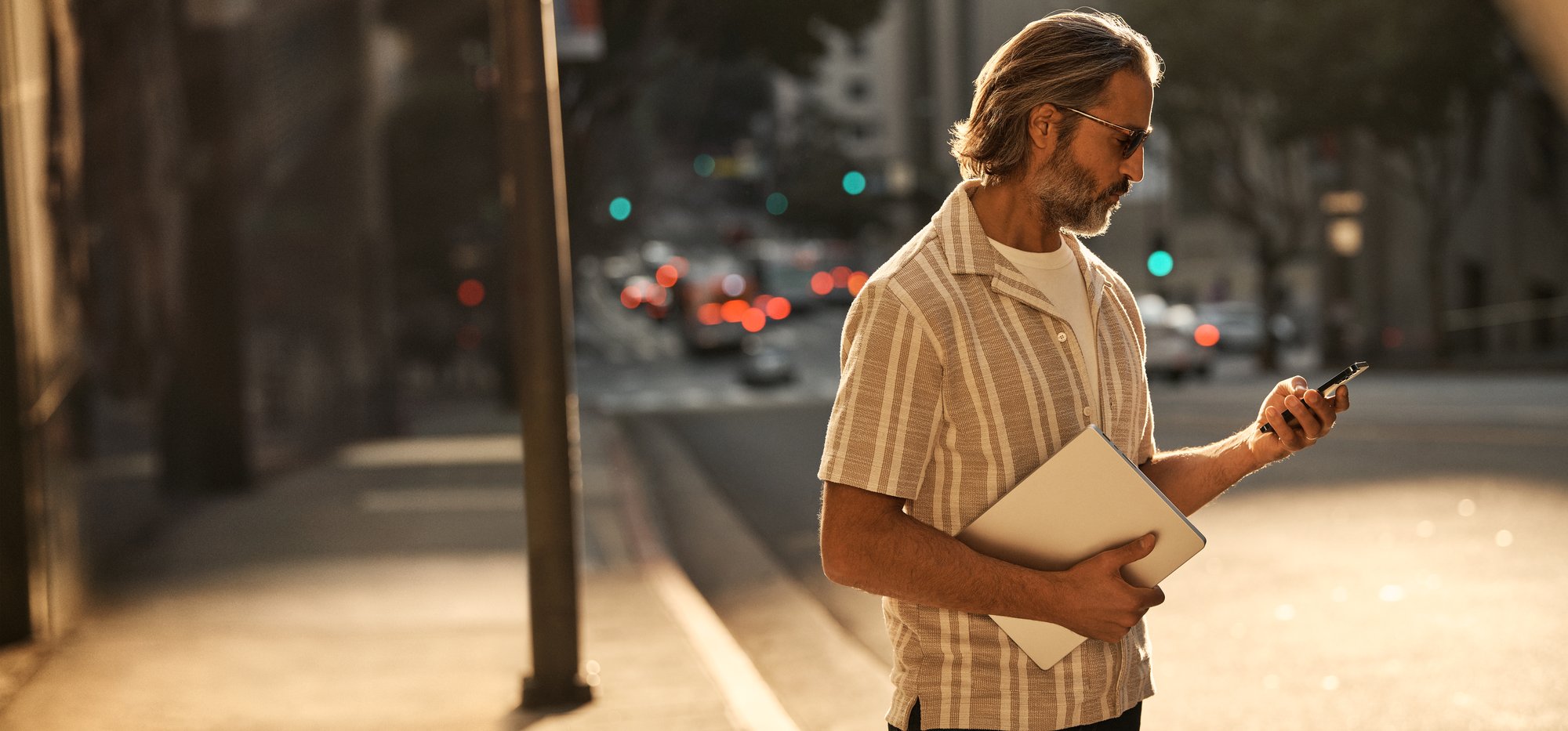 Man standing on a curb looking at his phone